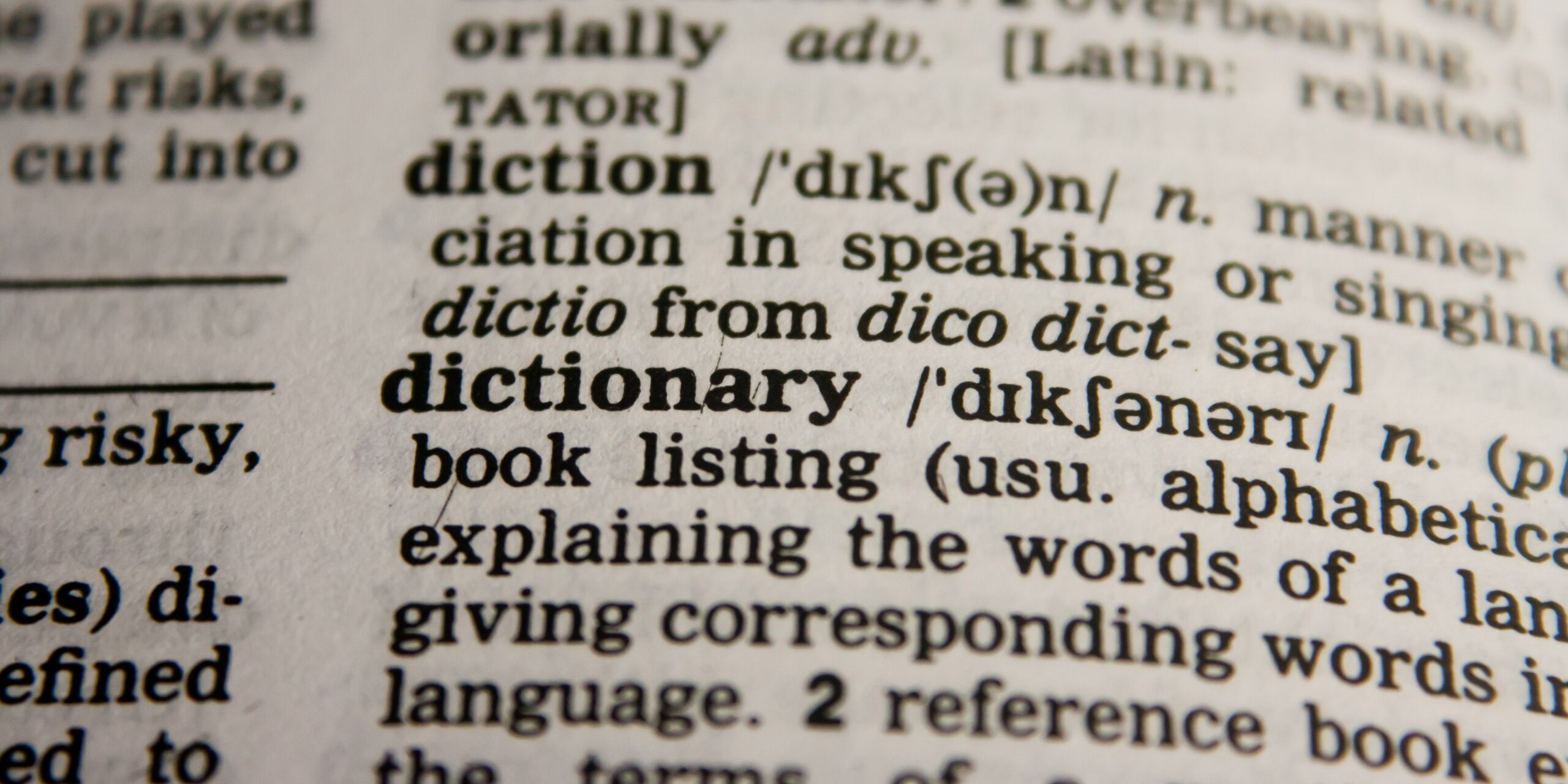 Primerísimo plano de una página de un diccionario de inglés mostrando la palabra 'diccionario'