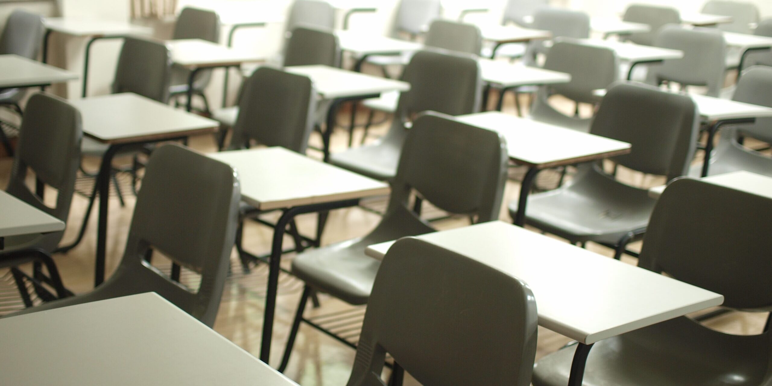 Pupitres vacíos en un aula.