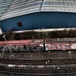 Vista desde una calle contigua muy elevada de las vías de tren que llevan a la estación de mercancías de Bilbao, en Santurtzi. Se ve, apartado en una vía secundaria, una unidad de S-446 profusamente vandalizada.