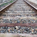 Una vía férrea sobre balasto con traviesas de madera.
