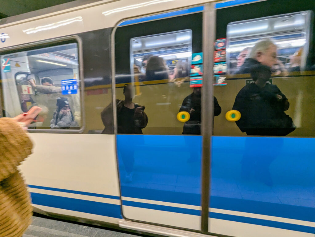 Un tren de la línea 3 de Metro de Madrid pasa absolutamente abarrotado, con gente pegada a las ventanas.