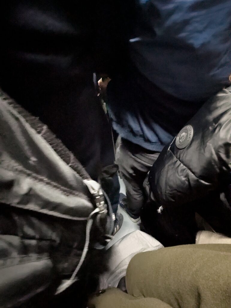 Pasajeros apiñados en un tren de Metro de Madrid. Foto mirando hacia el suelo, del que solo se ve una parte pequeñisima donde no cabe un pie más.