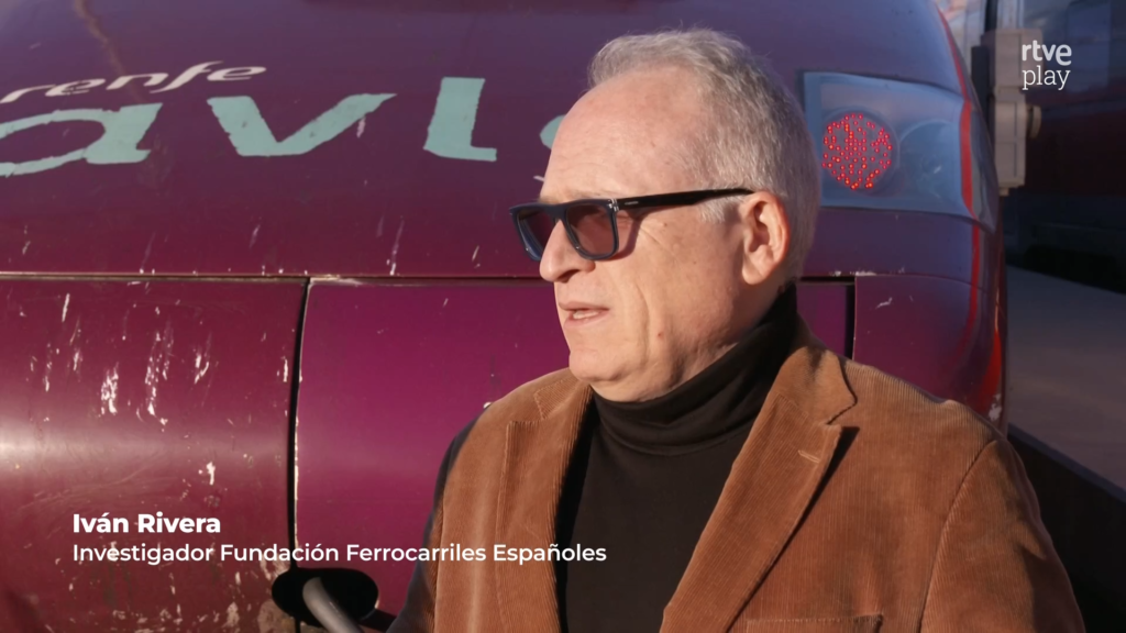 Iván Rivera contando cosas frente al morro de un Talgo S-102 con librea Avlo.